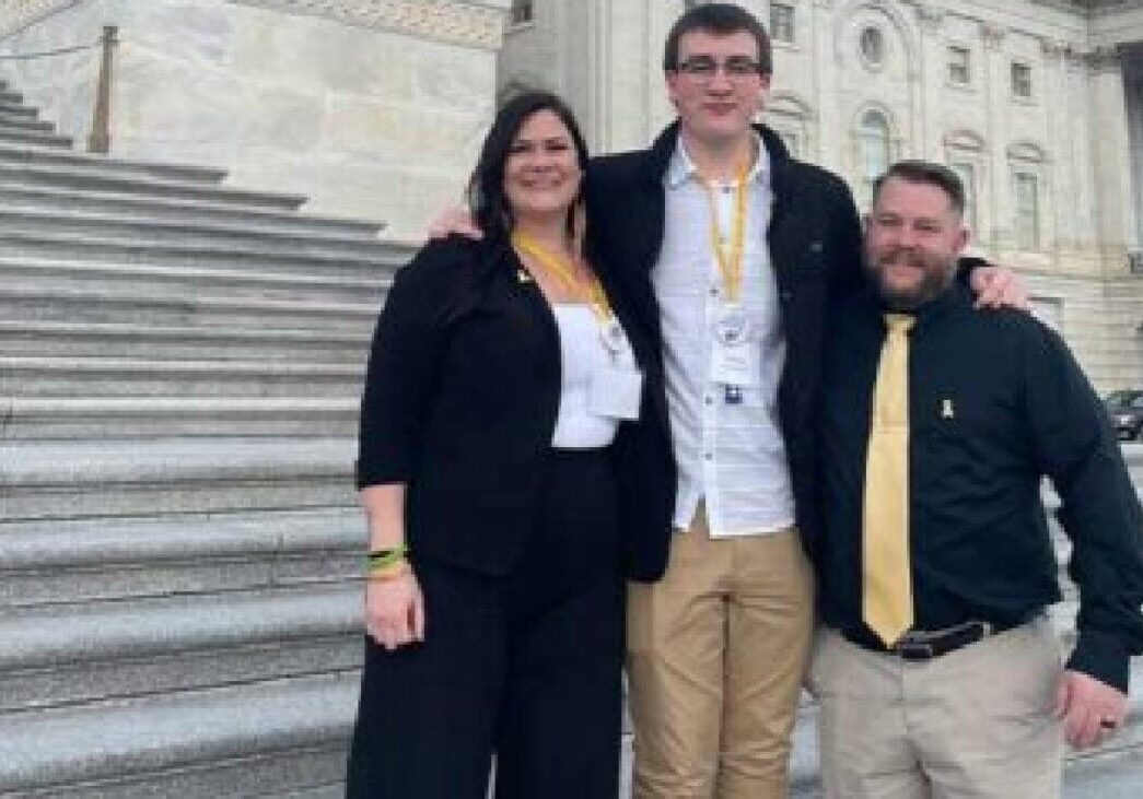 College students at Camp One Step, standing on historical steps in front of a grand building.