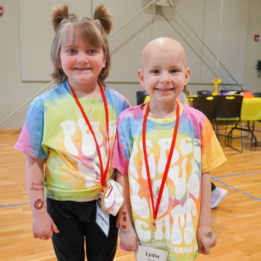 Happy children at Camp One Step smiling for a photo in colorful tie-dye shirts.